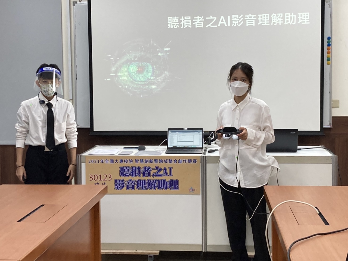 陸妍諭同學（左）、潘欣余同學在比賽現場，報告「聽損者之AI影音理解助理」