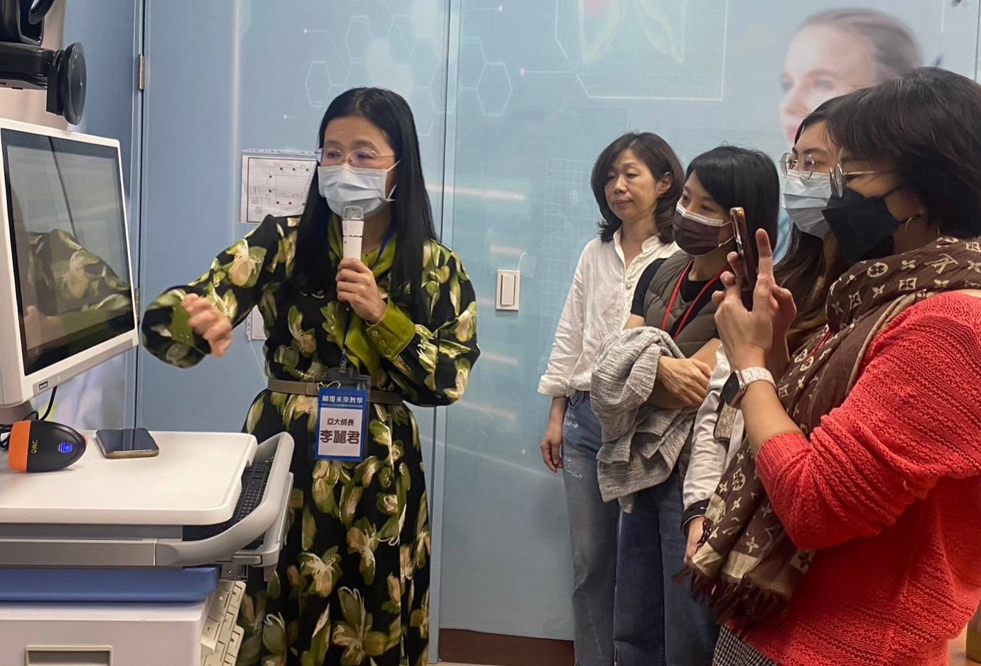 圖為參加實體場研討會學員，在亞大護理學院未來護理中心，體驗生成式AI虛擬人在身體評估課程的運用。