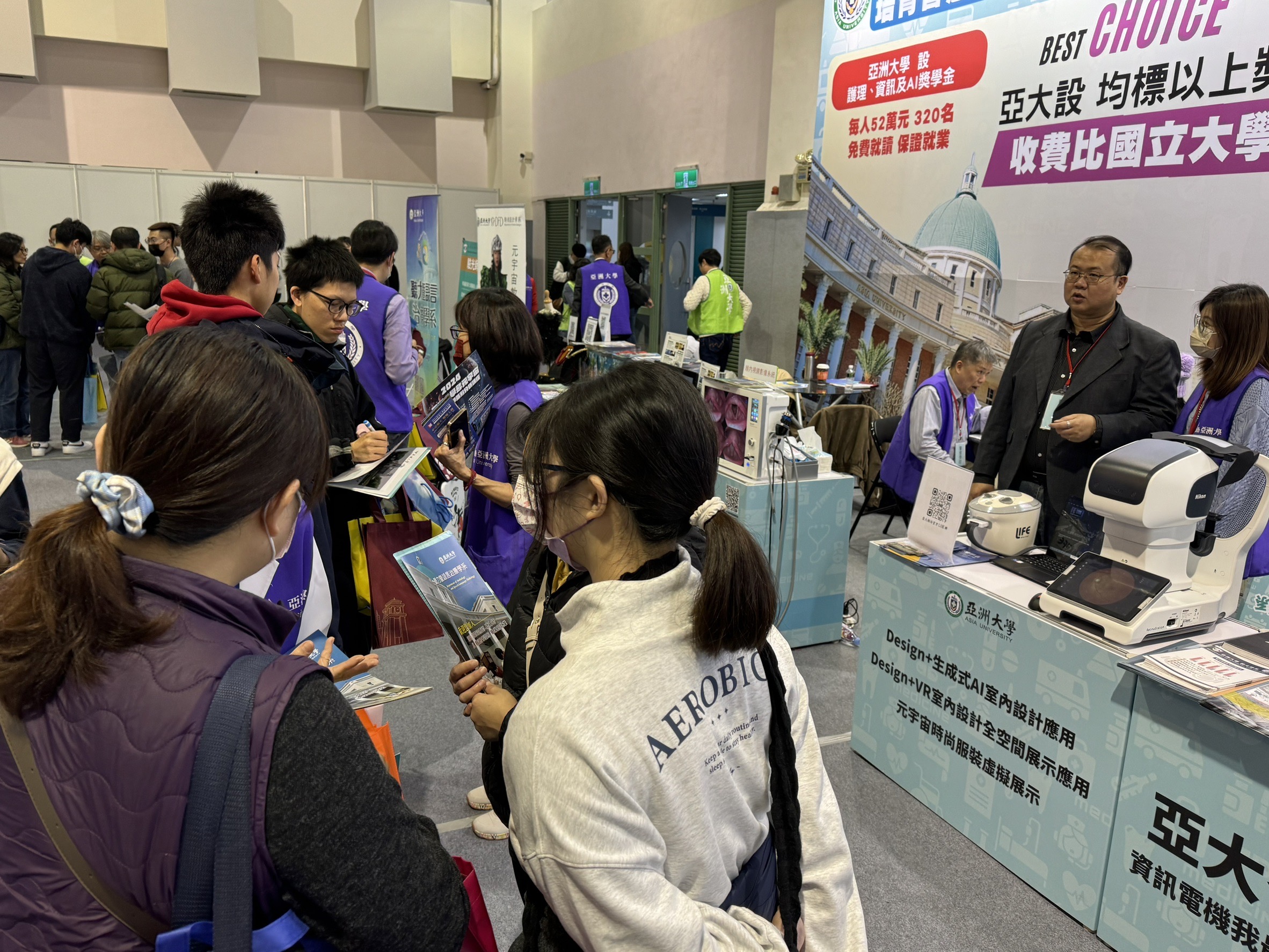 2024大學博覽會台北場，亞大攤位擠滿考生，仔細詢問有興趣就讀科系及獎學金。